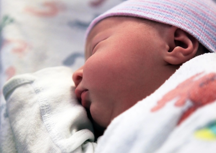 Sleeping newborn baby in hospital. The first hours of life of the newborn girl